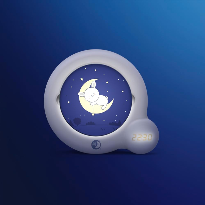 Pabobo Kid'Sleep Essential z tarczą przedstawiającą królika na księżycu, zdjęcie na niebieskim tle.