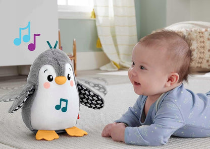 Dziecko leżące na brzuchu obok szarego pingwina Fisher-Price z grafiką nutek.