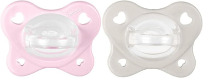Dwa smoczki Chicco PhysioForma Dual Soft, różowy i szary, z przezroczystymi końcówkami.